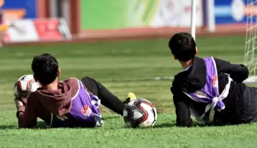 Top toplayıcı gençler maç sırasında plajda güneşlenir gibi güneşlendi